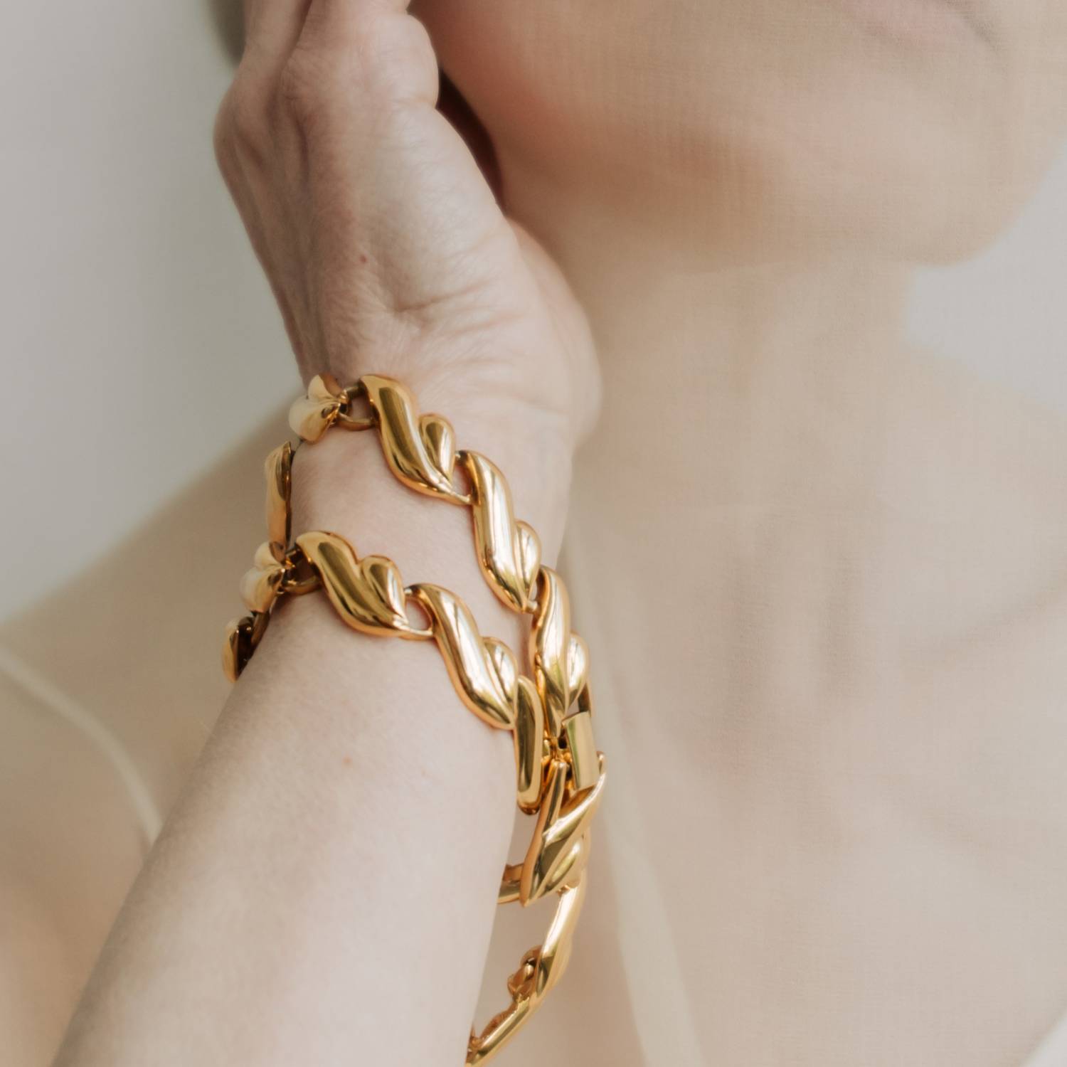 Gold-tone link bracelets on a wrist
